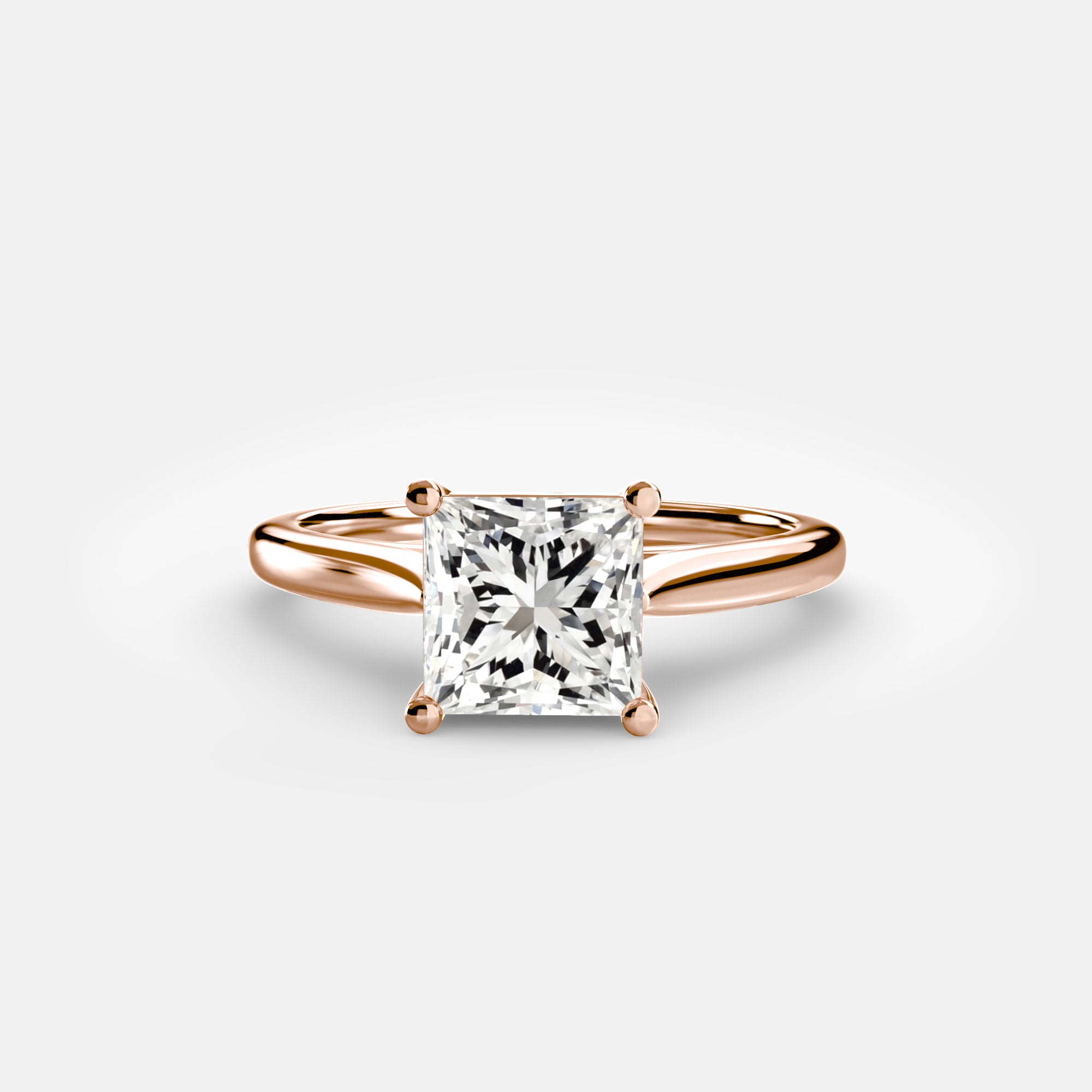 Rose gold ring with a large diamond on a light gray background
