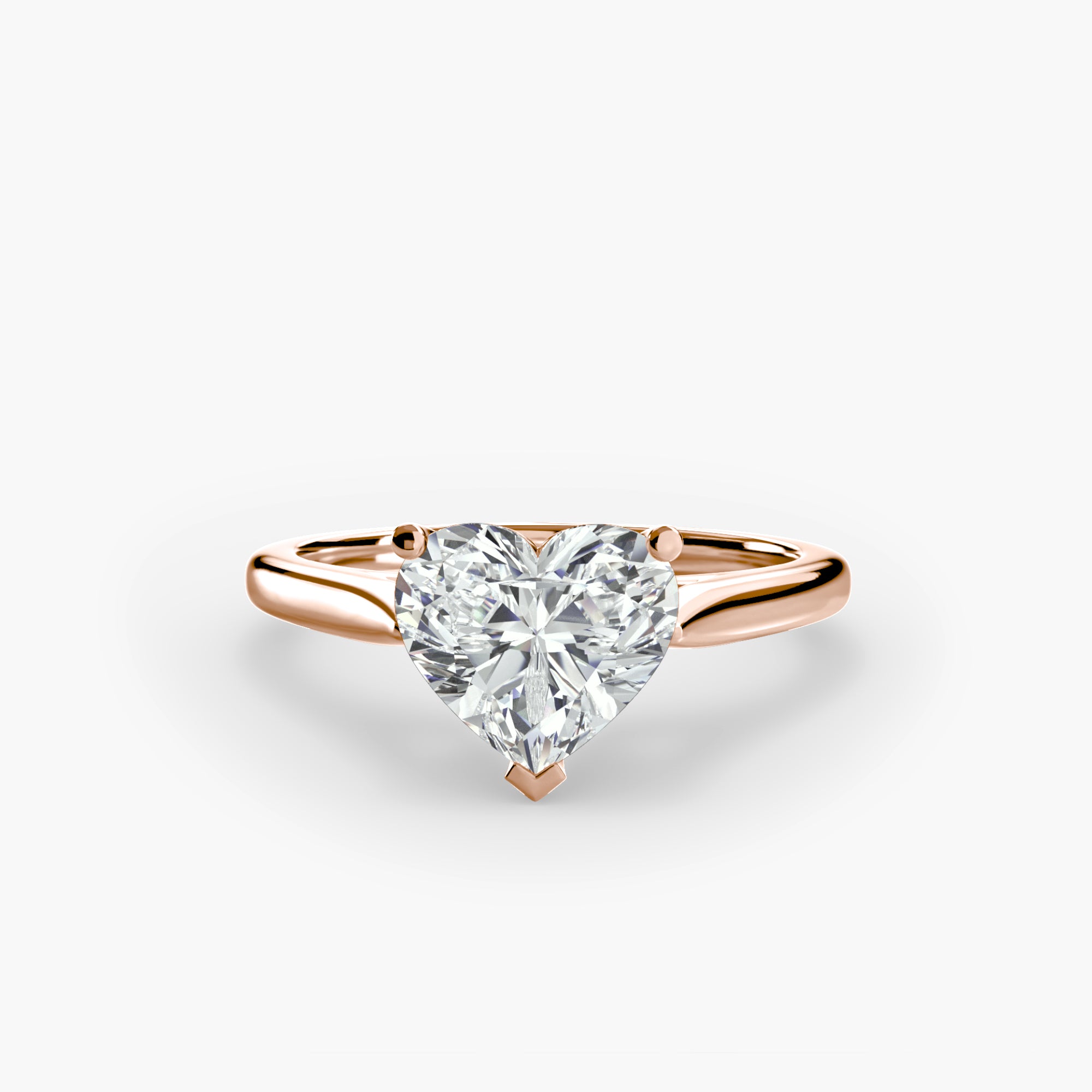 Rose gold ring with a heart-shaped diamond on a white background